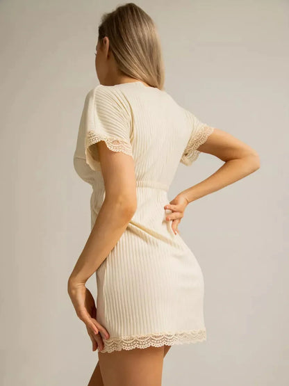 Model wearing a cream ribbed mini dress with lace trim, showcasing a stylish back view.