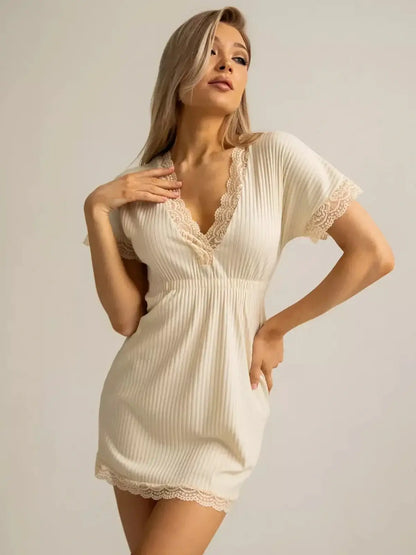 Elegant cream mini dress featuring ribbed texture and lace-trimmed V-neck, perfect for summer or evening wear.