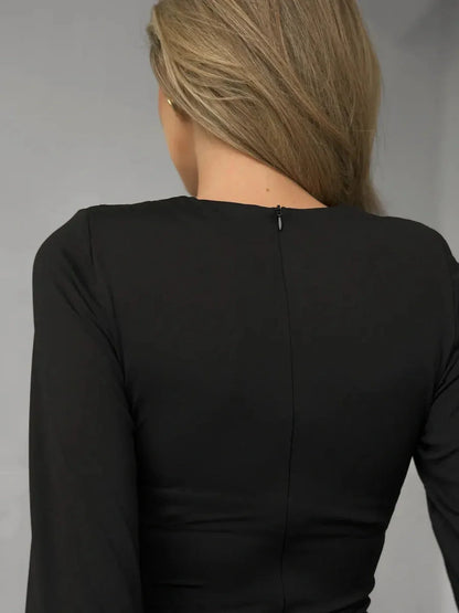 Back view of a sleek black dress showcasing elegant stitching and a zipper detail.