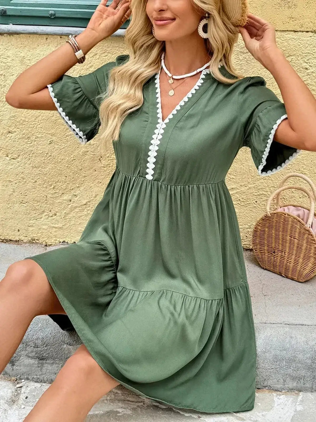 Model wearing a green Veranda Bloom Mini Dress with embroidered trim, perfect for summer and garden parties.