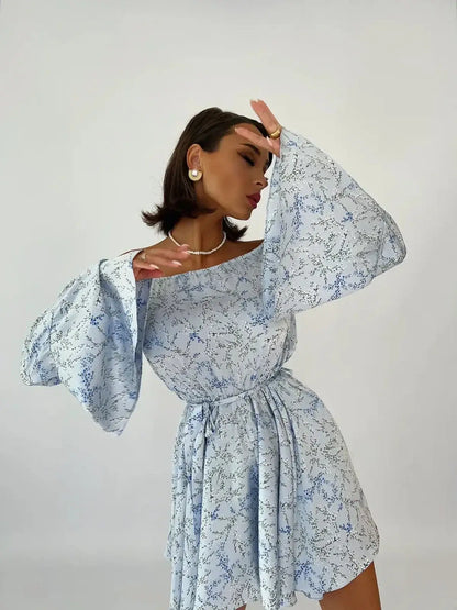 Model wearing the Whimsy Flair Mini Dress with off-shoulder neckline and bell sleeves, perfect for summer occasions.