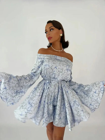 Model wearing Whimsy Flair Mini Dress with off-shoulder neckline and flowy bell sleeves, perfect for summer events.