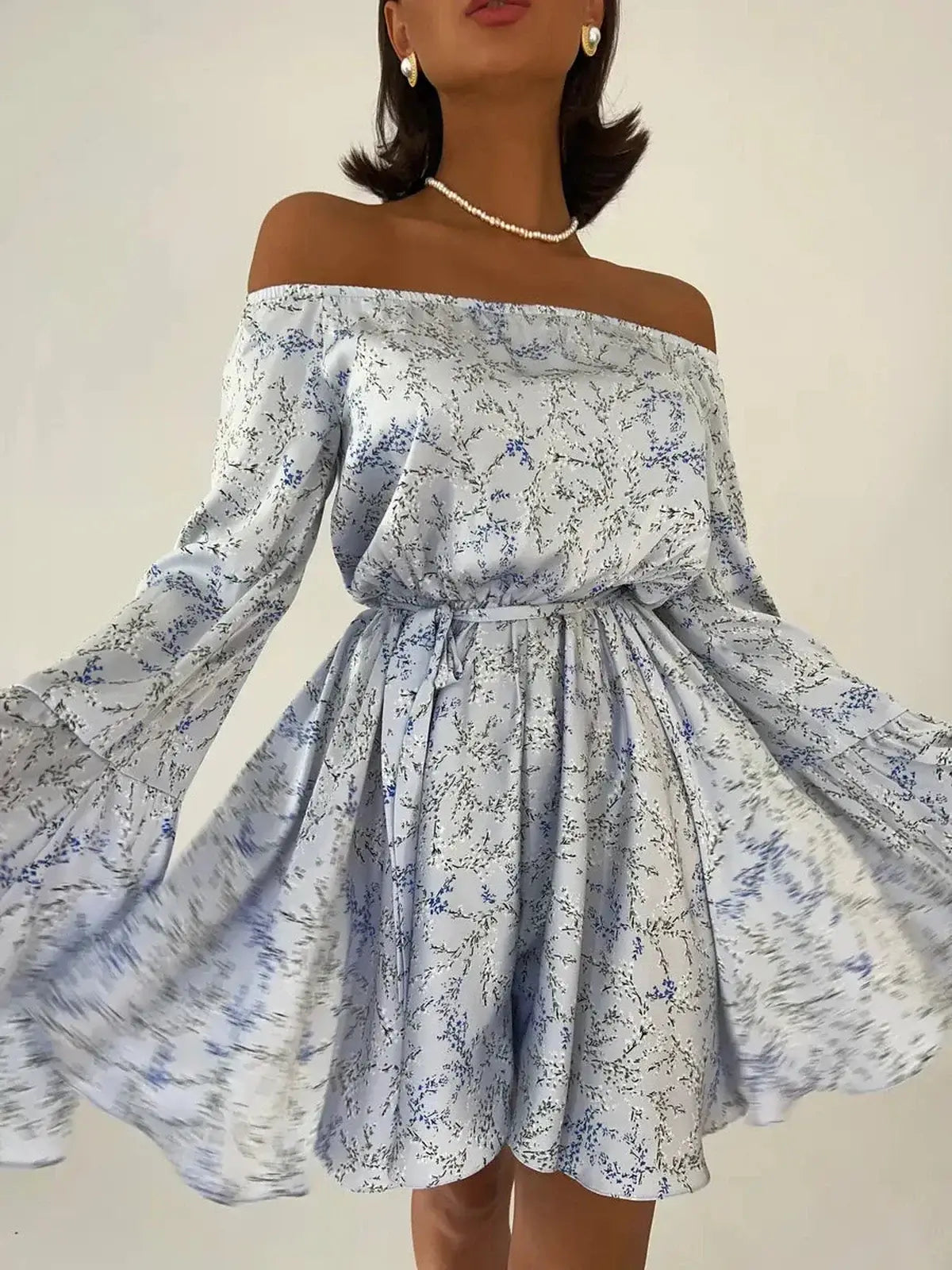 Off-shoulder floral mini dress with flowy bell sleeves and cinched waist, perfect for summer weddings and parties.