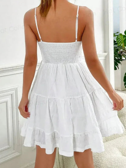 Back view of the Whisper Charm Mini Dress, a white sundress with tiered skirt and spaghetti straps, perfect for summer.